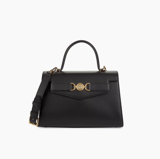 a black top handle versace bag in front of a plain backdrop