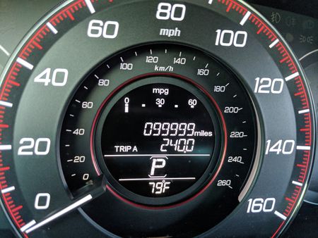 A car's odometer reading 99,999 miles.
