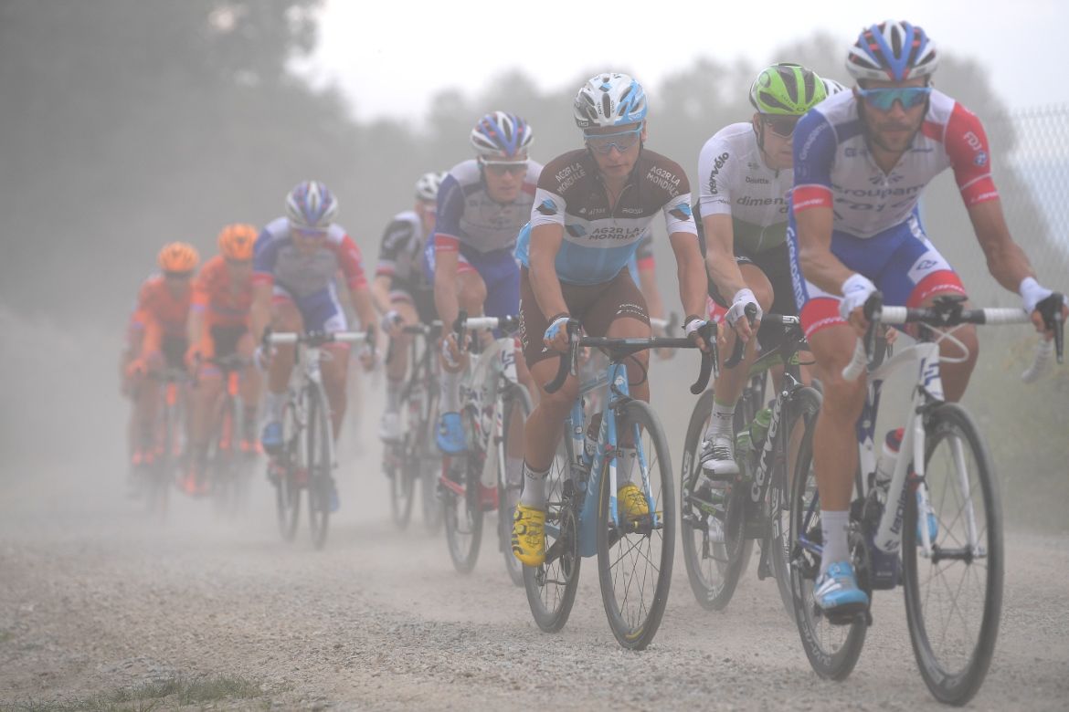 Thibaut Pinot powers across the gravel road