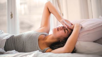 best mattress for back pain: woman in bed looking uncomfortable