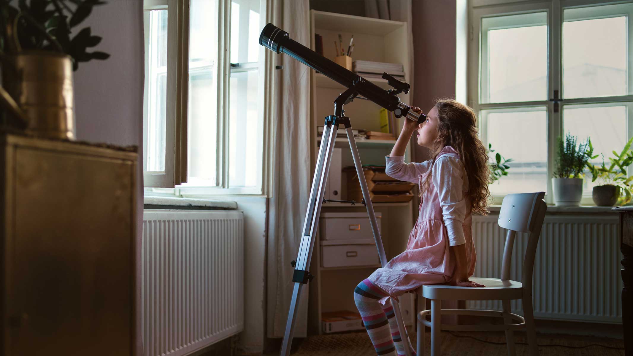 Girl with telescope in front room