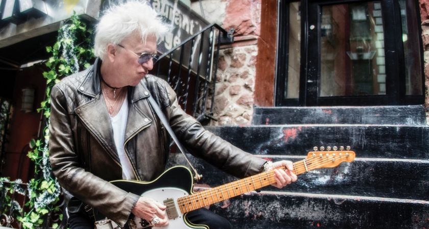 Ricky Byrd wears a weathered biker jacket and throws a pose as he plays a Telecaster on the stoop of a NYC apartment.