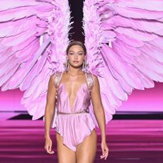 Gigi Hadid wears a pink romper from the Victoria's Secret Fashion Show with pink angel wings