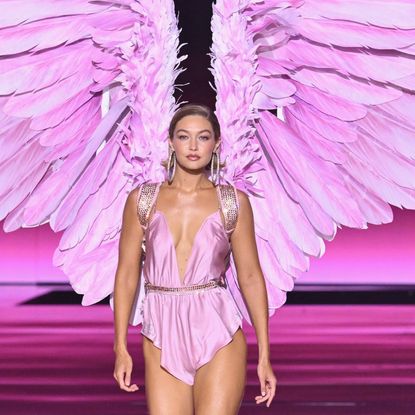 Gigi Hadid wears a pink romper from the Victoria's Secret Fashion Show with pink angel wings