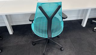 Herman Miller Sayl gaming chair from the back, next to a desk