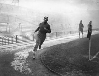 Arsenal's Ted Drake runs around the pitch after a game against Bolton Wanderers was called off in 1935.