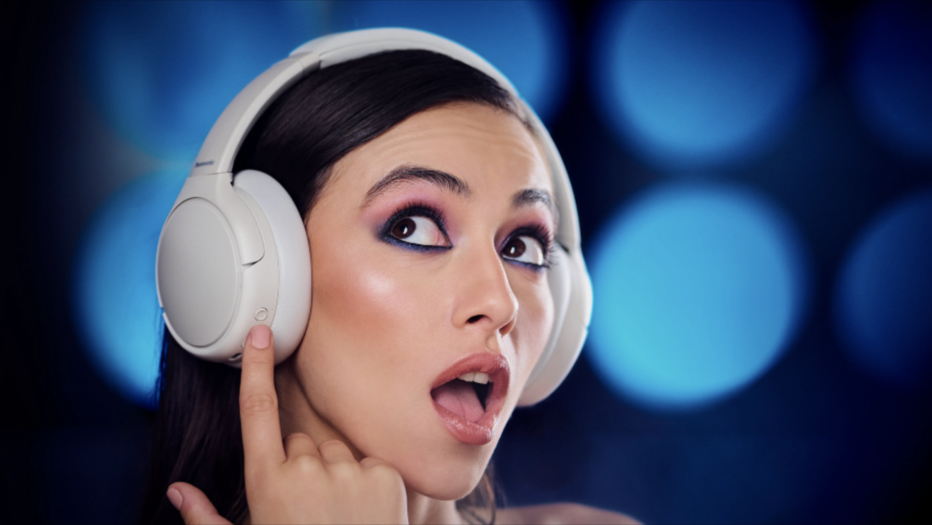 Panasonic RB-M6000B headphones worn by a woman on blue background