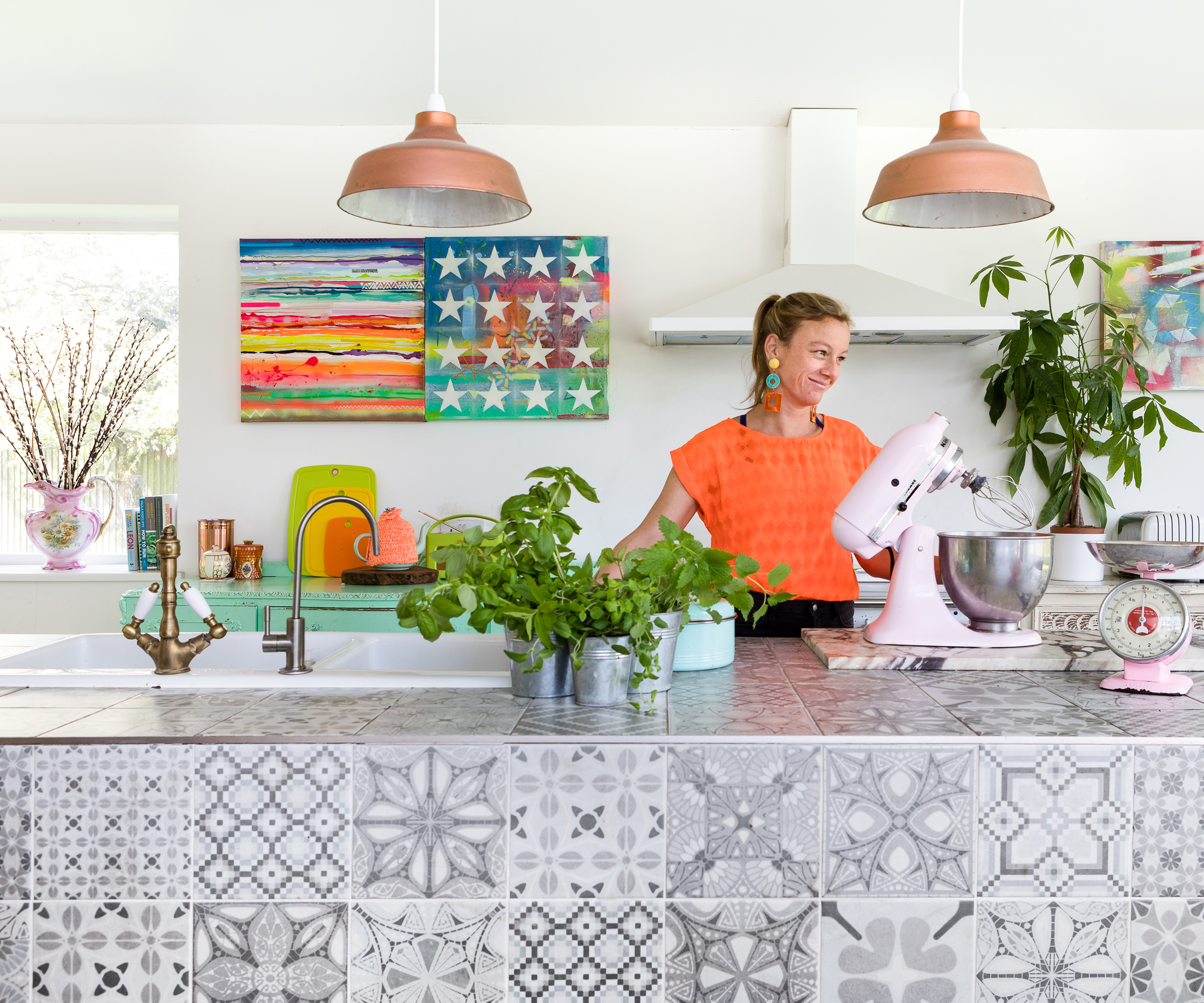 Tiled kitchen island with two copper pendant lights above