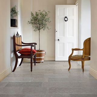 flagstones flooring with cream wall and white door with chairs