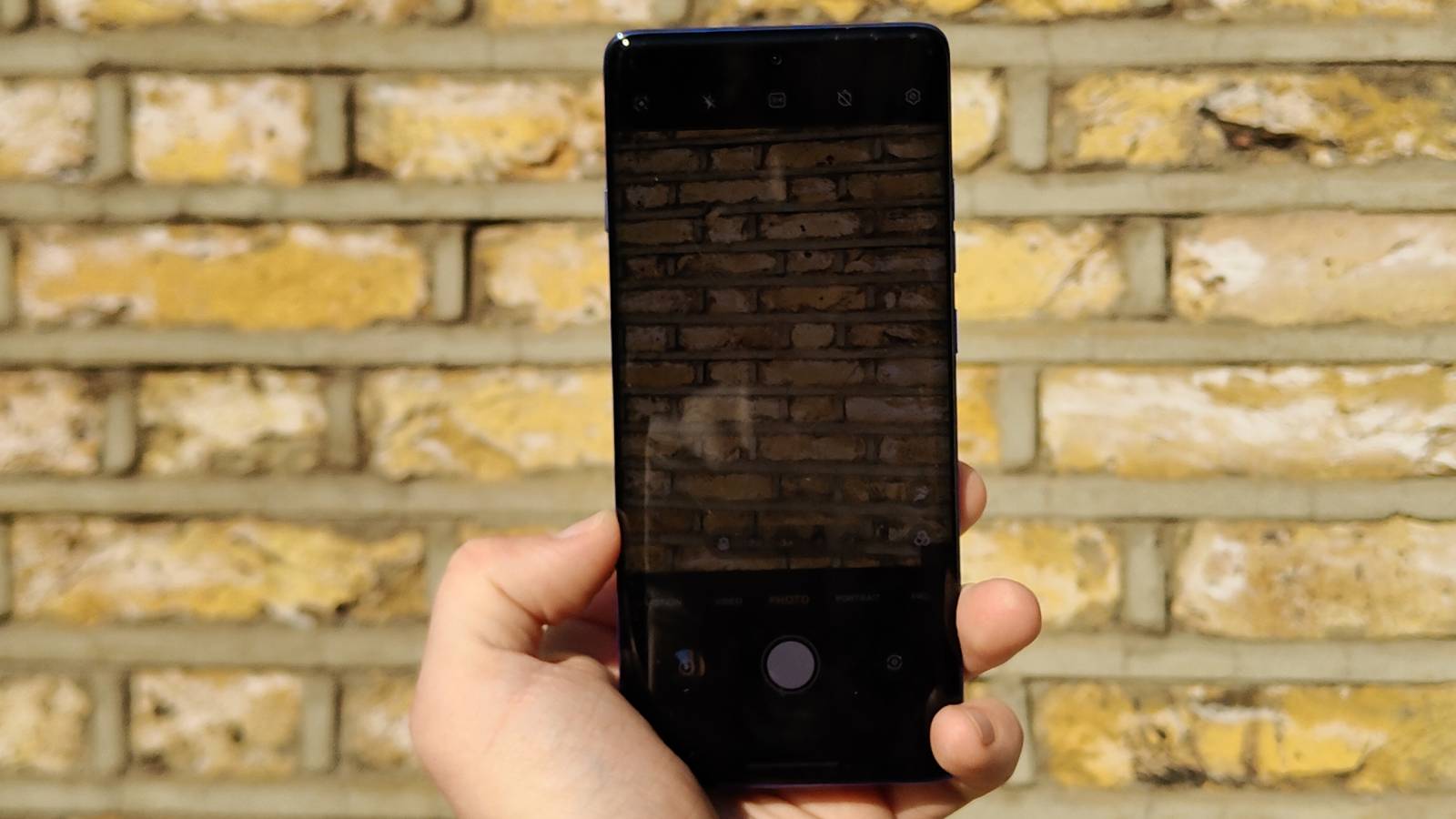The Motorola Edge 60 Pro above a brick wall.