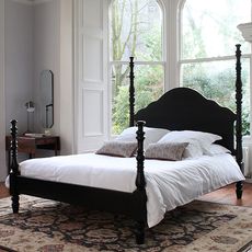Ebony Kingston bed with white bedlinen on carpet in bedroom by window