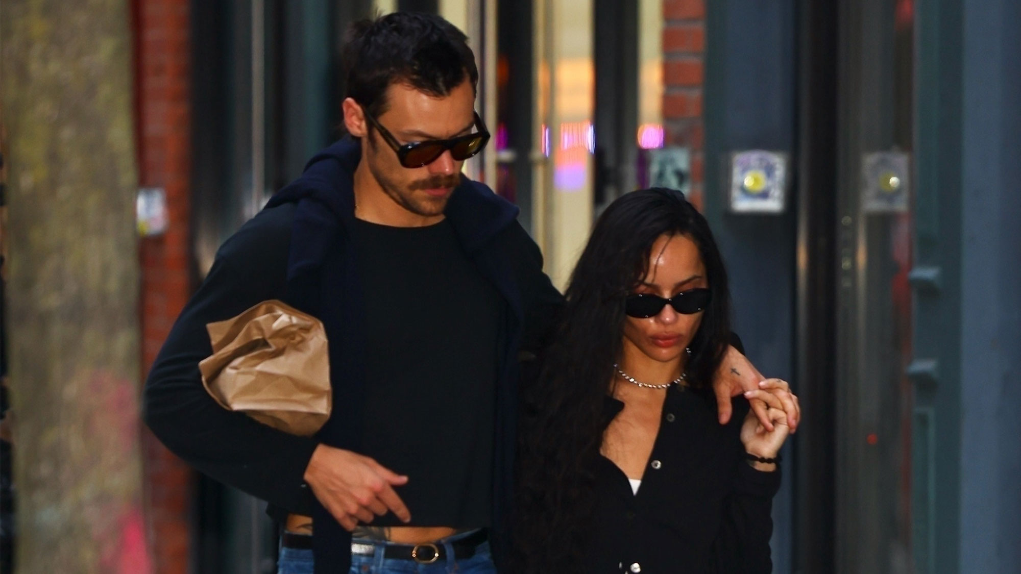 Harry Styles in a long-sleeve shirt and jeans with Zoe Kravitz