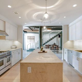 kitchen area with wooden counter and white kitchen cabintes