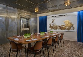 The former vault inside the 21 C Museum Hotel in Lexington now holds a dining table and large portrait of a gold bird