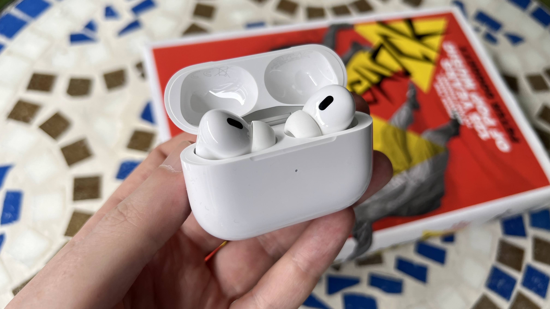 AirPods Pro 2 di atas meja mosaik