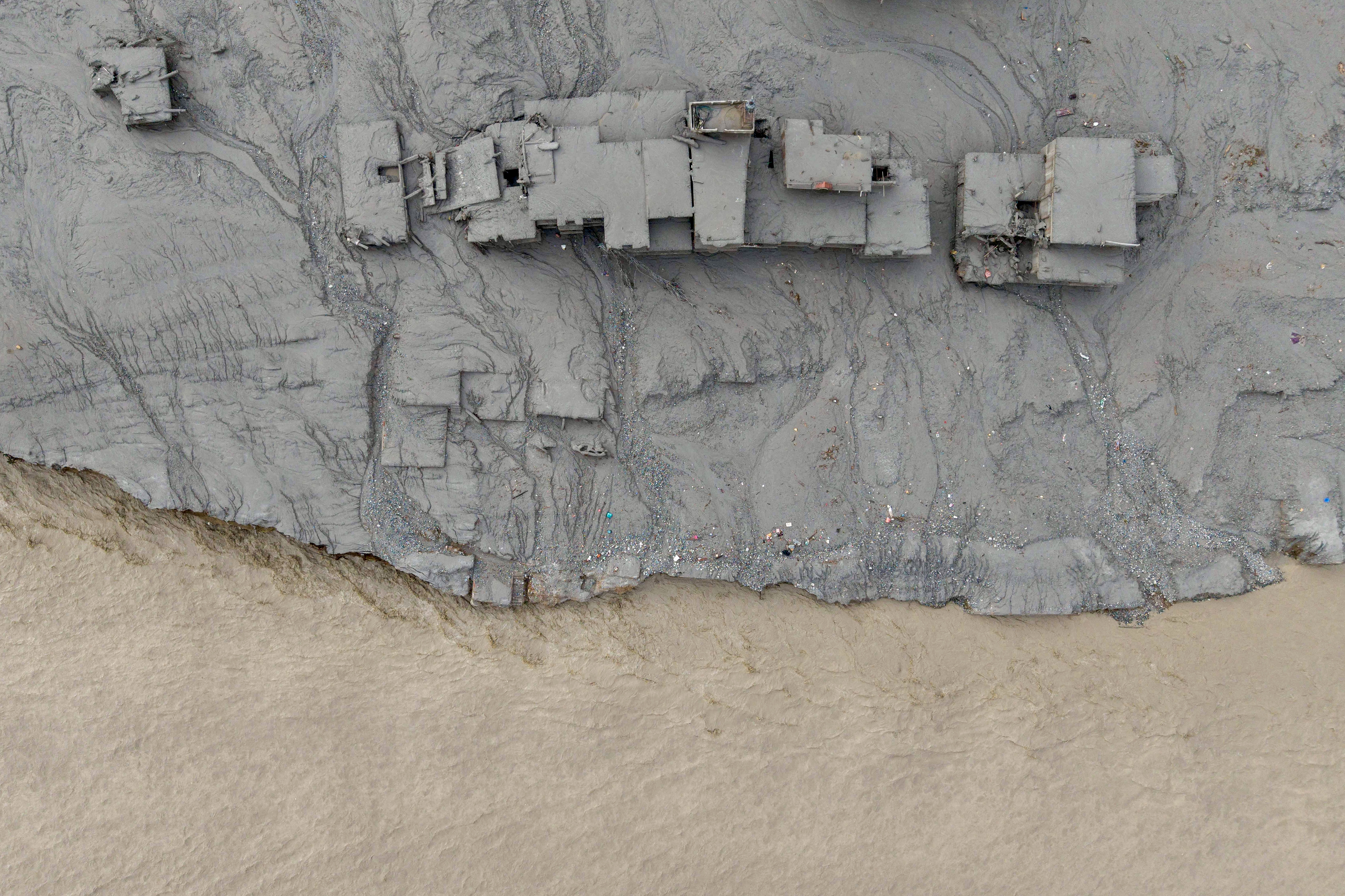An aerial view shows houses lying deluged in sludge after flash floods at Devighat, Bidur Municipality in Nepal's Nuwakot district on August 27, 2026. Nepal's disaster agency said that 823 people remained out of contact on August 27, more than 24 hours after a deadly flood tore through the border region with Tibet. (Photo by Prabin RANABHAT / AFP)