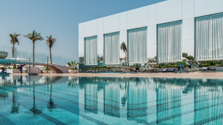 External shot of SAL at Burj Al Arab, with swimming pool and palm trees