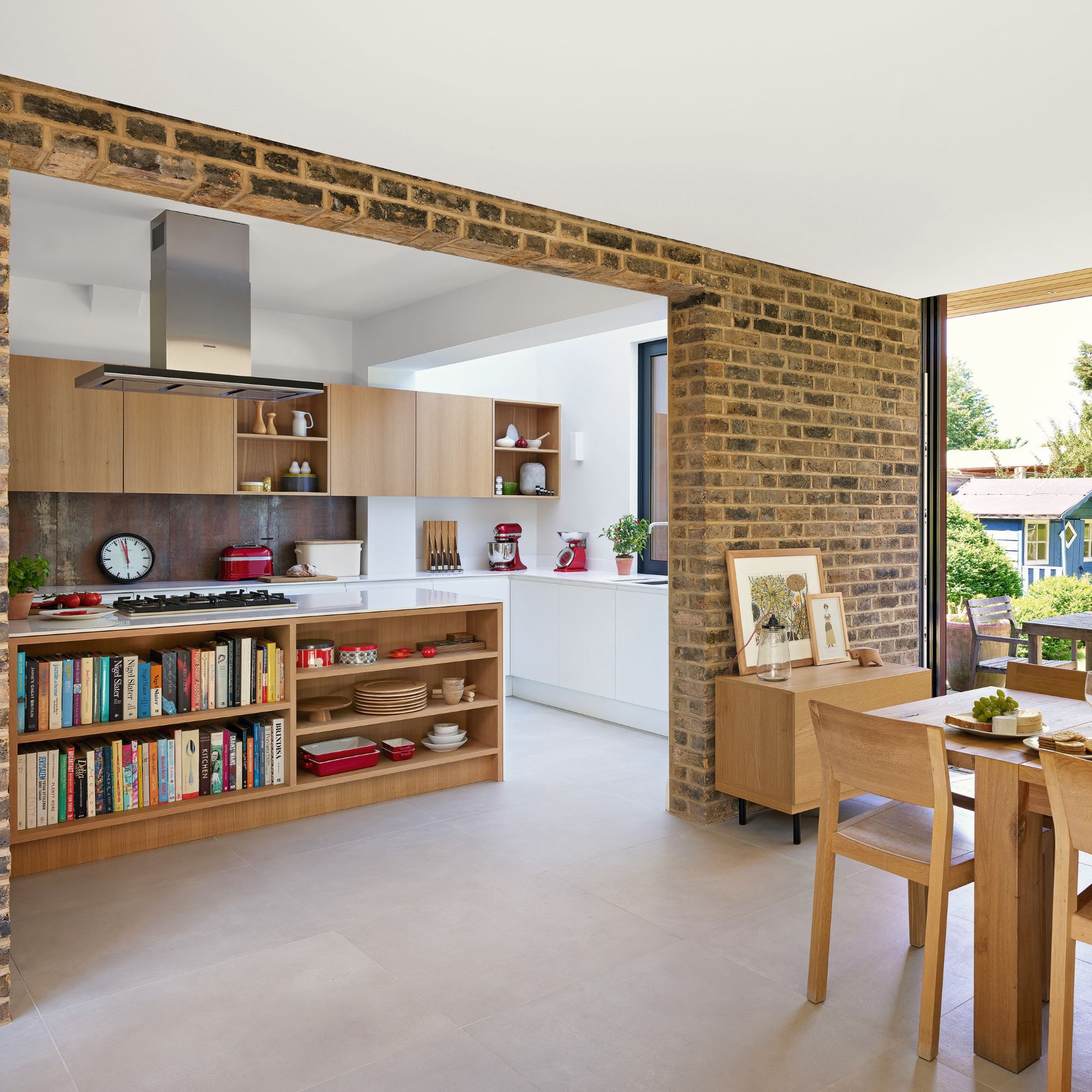 Open plan kitchen with wooden furniture and brick walls
