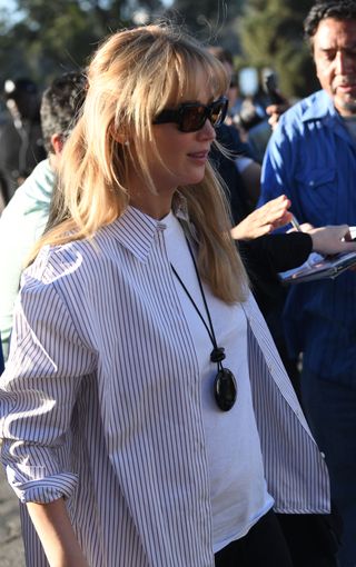 Jennifer Lawrence wore a chunky pendant necklace layered over an open button-up shirt.