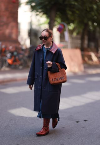 woman wearing lengthy barn jacket and cowboy boots