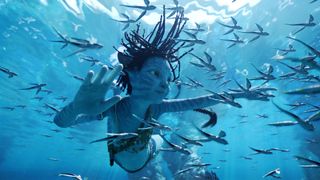 Still from the movie Avatar: The Way of Water (2022). Here we see a young Na'vi (blue skin, long dark hair) enjoying their time floating underwater.