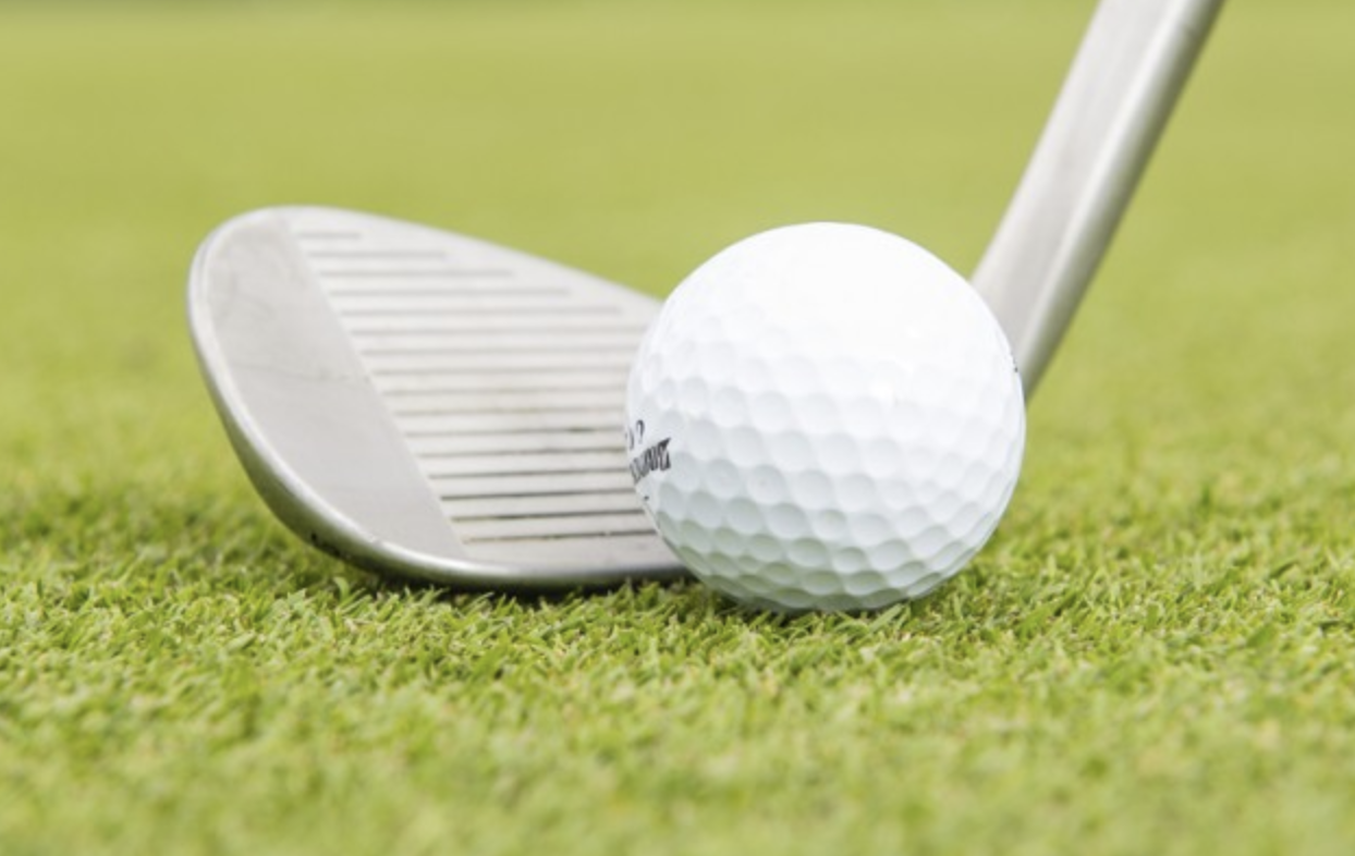 Close up of a wedge and golf ball