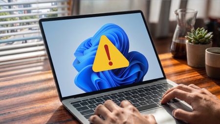 A Windows 11 laptop displaying a large warning sign
