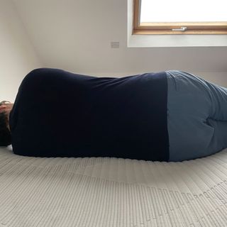 person lying down on bed in a white room