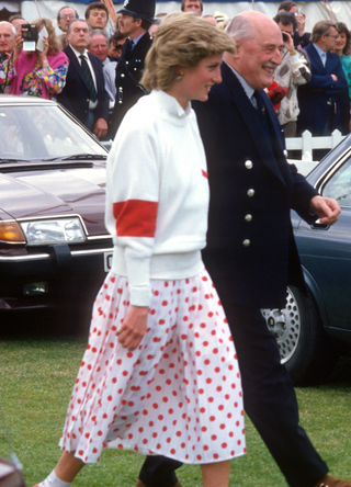 Diana, Princess of Wales, wearing a red and white polka dot skirt designed by Mondi with matching socks, a white jumper and red shoes, attends a polo match at Guards Polo Club in June 1986 in Windsor, United Kingdom