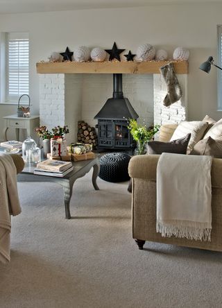 country cream living room with a black log burner stove with subtle Christmas decorations