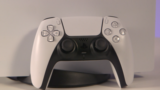 Control de DualSense de PS5, recargado sobre la consola PS%