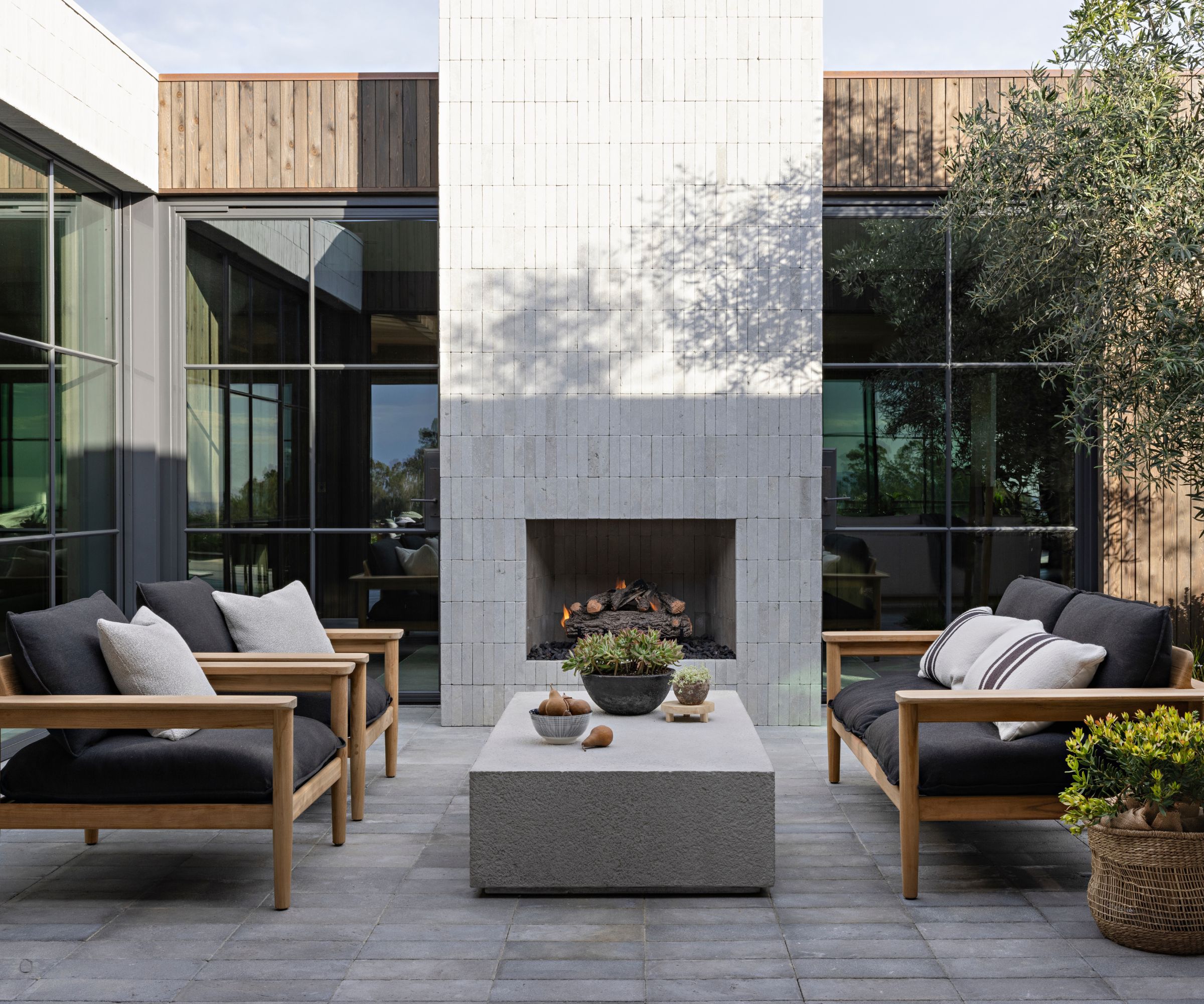 Outside patio with sofas and stone coffee table and tiled outdoor fireplace