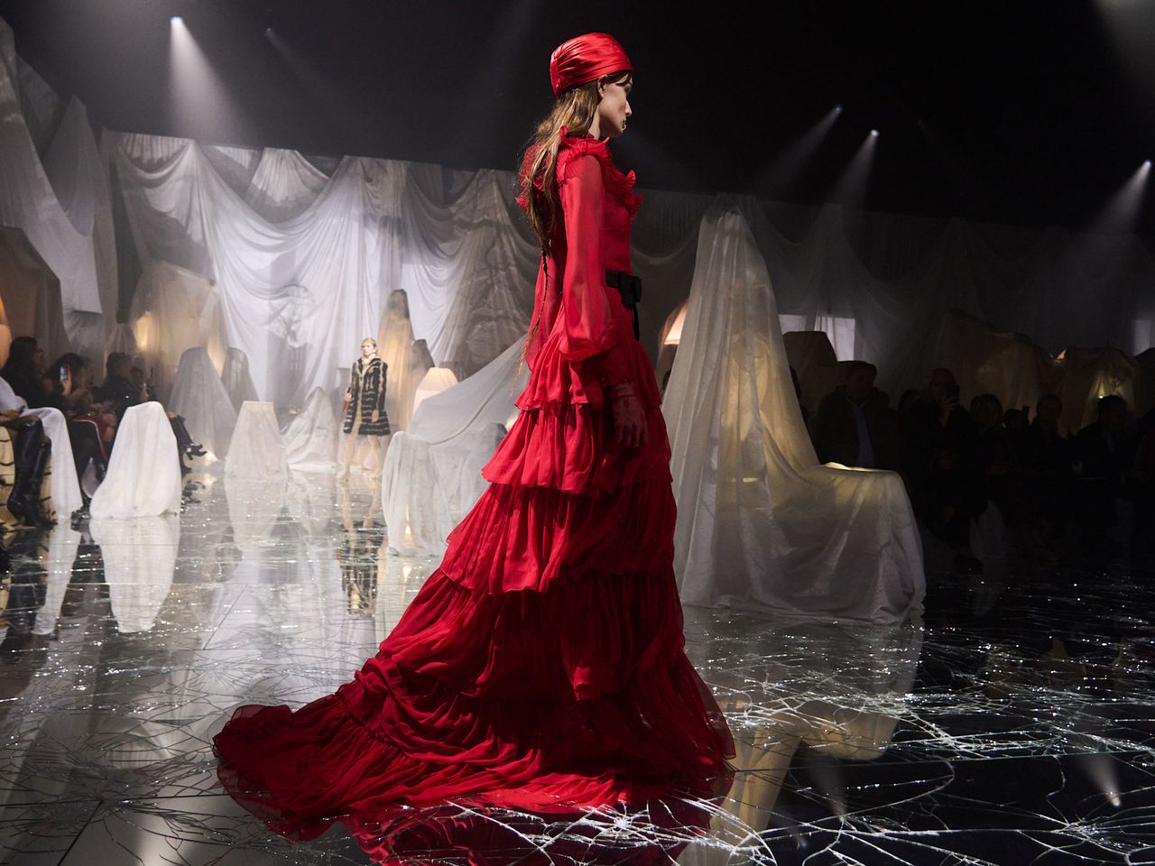 a model wears a long red dress on the Valentino runway 