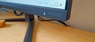 A dark slate Philips Evnia 25M2N5200P monitor on a wooden desk