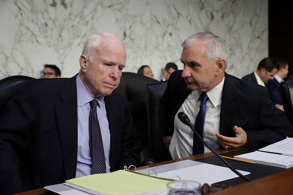 Committee chairman Sen. John McCain listens to Sen. Jack Reed before a Senate Armed Services Committee hearing. 