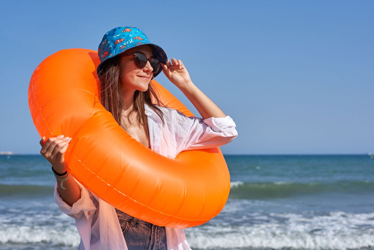 A woman stands on a beach in a rubber ring (image: Getty Images)