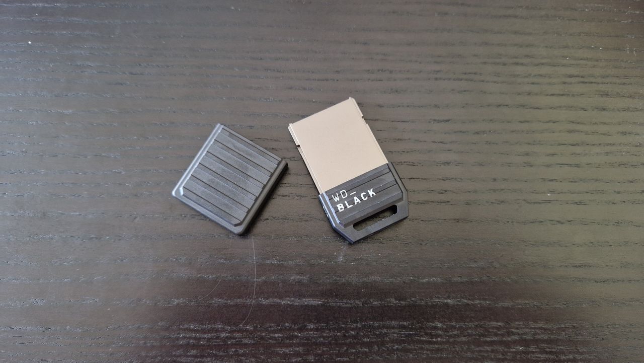 WD Black C50 expansion card for Xbox Series X and S sitting on a black wooden desk with the plastic shield off sitting next to it
