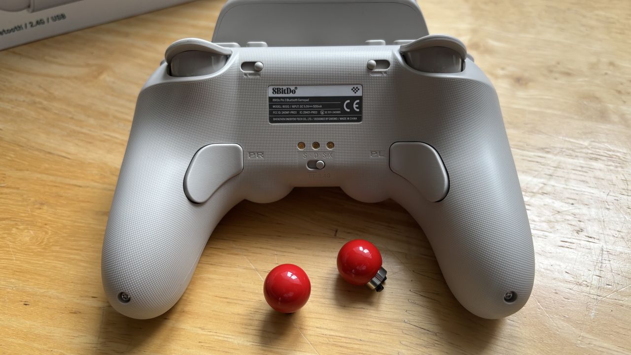 The 8BitDo Pro 3 controller photographed on a wooden table.