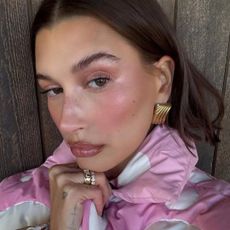 Hailey Bieber taking a selfie with glossy lips.
