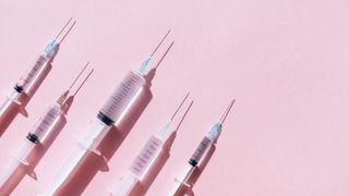 five needles of different sizes on a pink background