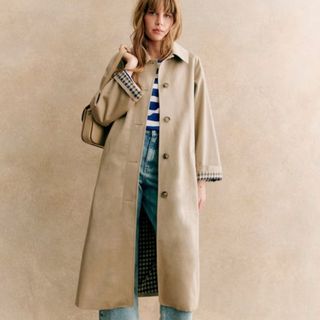 A model wears the Sezanne trench coat over a jumper and jeans