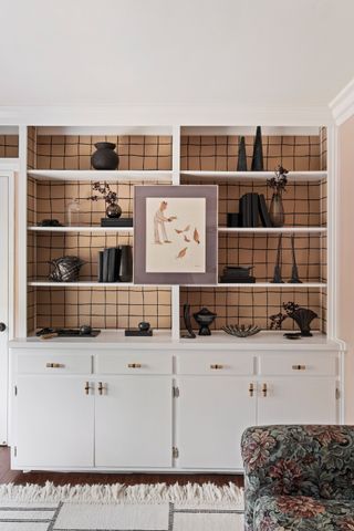 white built-in bookshelf with wallpaper back and bamboo handles