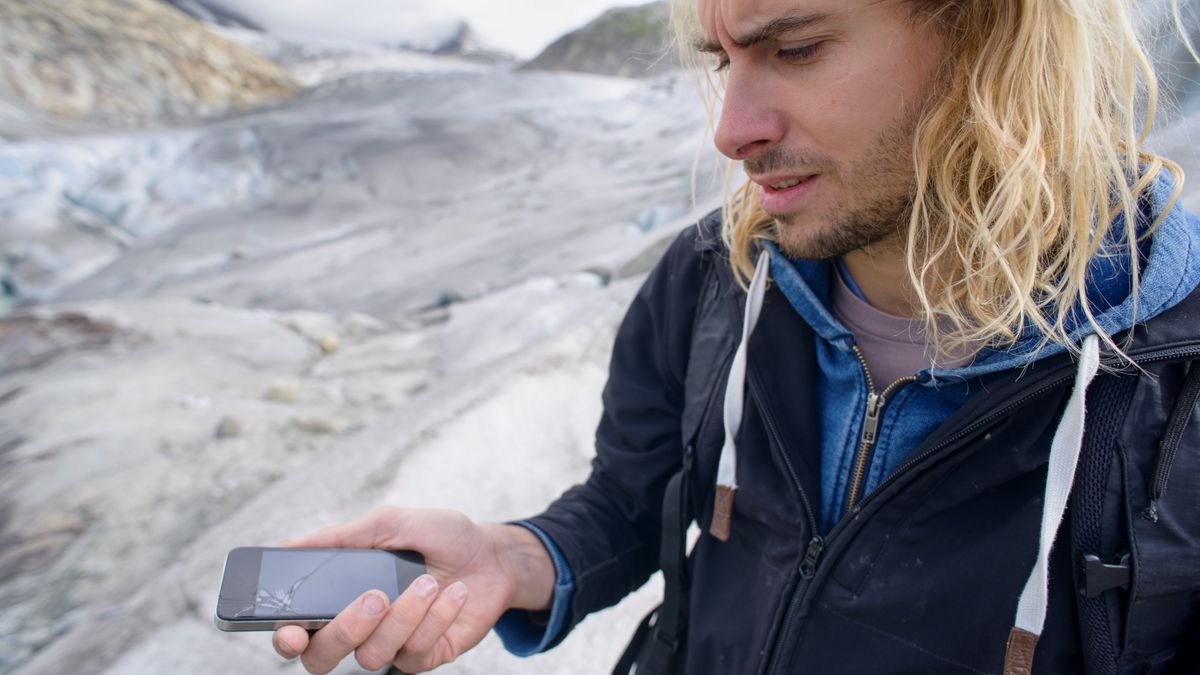 Hiker with broken phone in the mountains