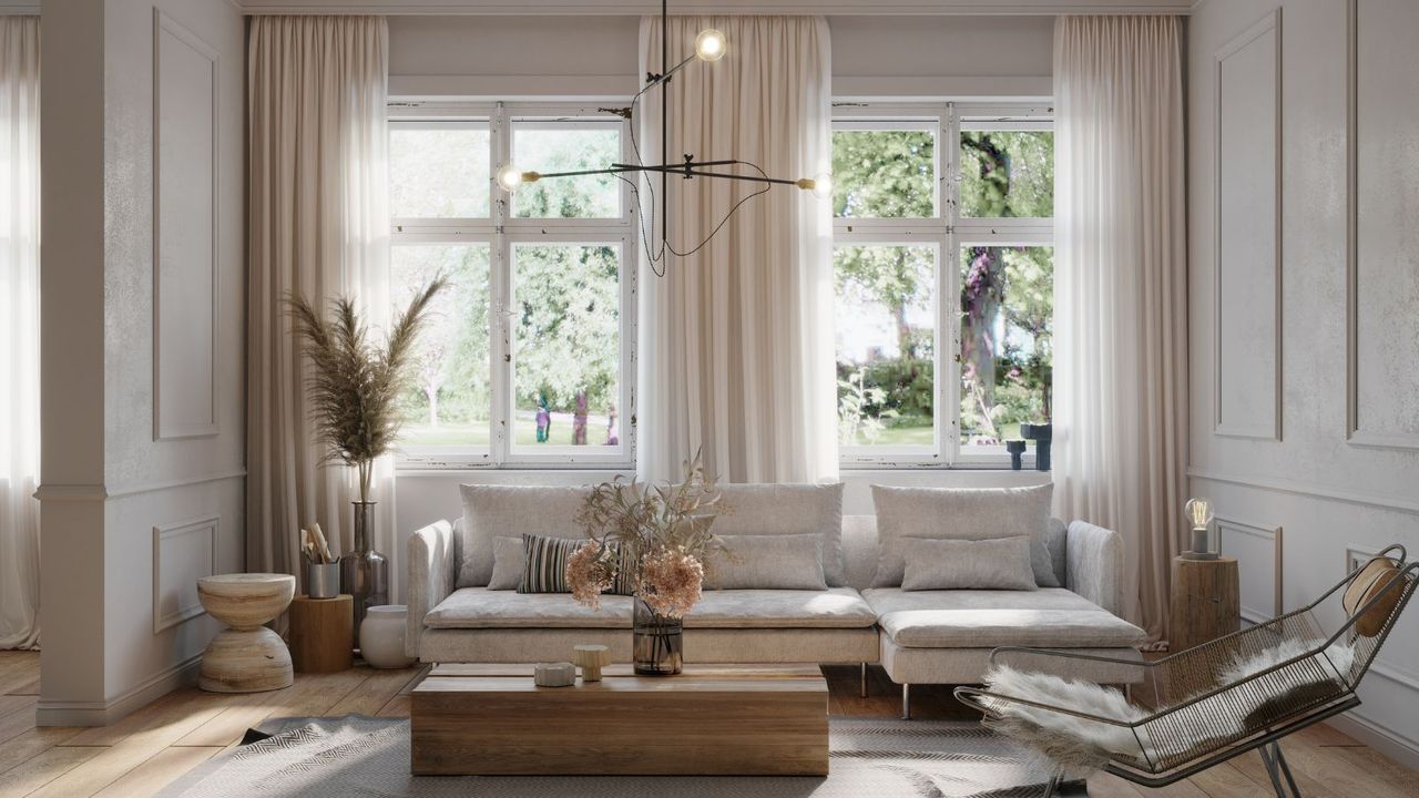 A bright, neutral living room with modern, minimalist furniture and large windows with sheer white curtains