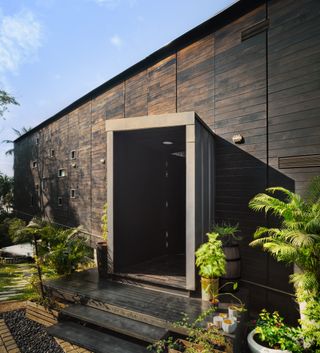 The facade is clad in charred timber