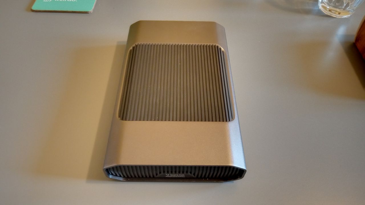 A grey aluminium SanDisk Professional G-Drive HDD on a table