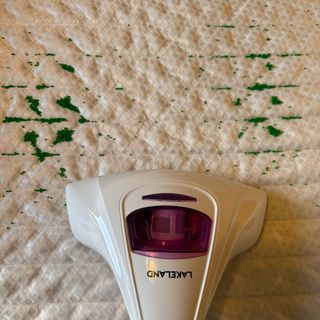 Mattress vacuum on a mattress after vacuuming a line through green sprinkles