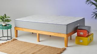 best mattress UK: The Nectar Memory Foam Mattress photographed in our testing studio on a light wooden bed frame and with a blue light shining in the corner