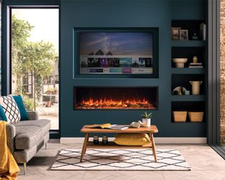 Wood burning stove below television in living room with blue paint decor