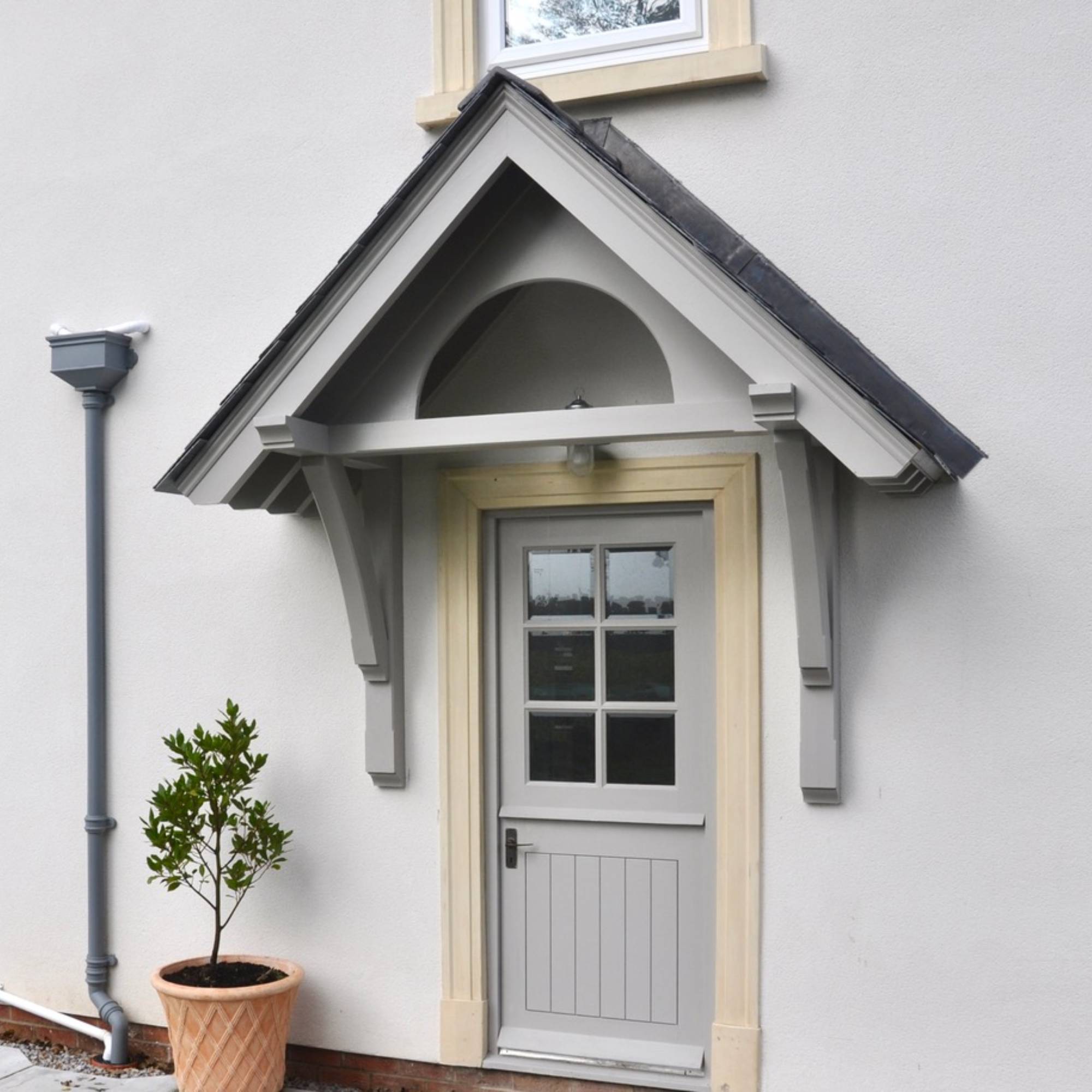 grey canopy porch above grey timber front door to grey house